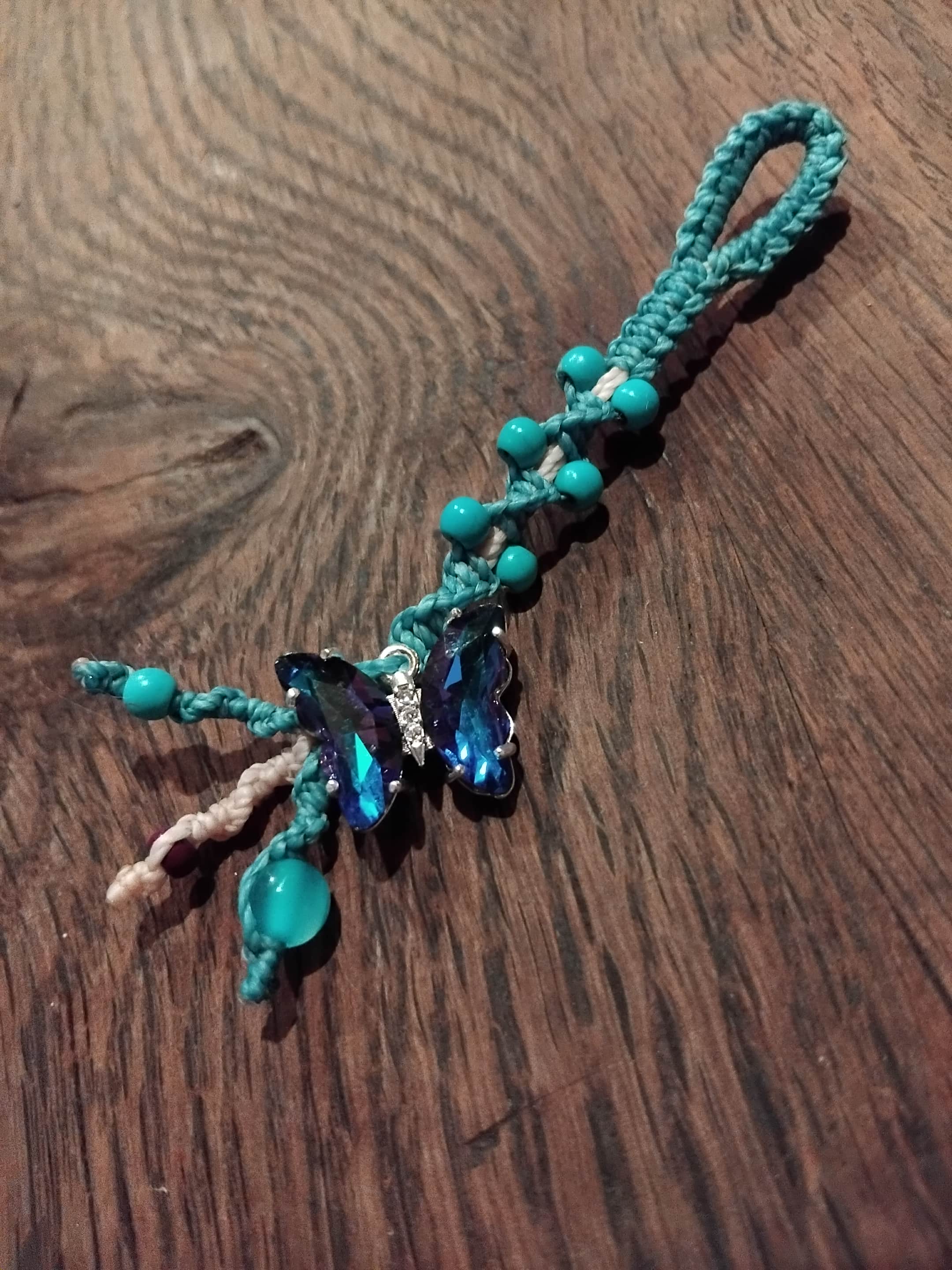 Turquoise macrame assemblage keychain with blue butterfly charm.