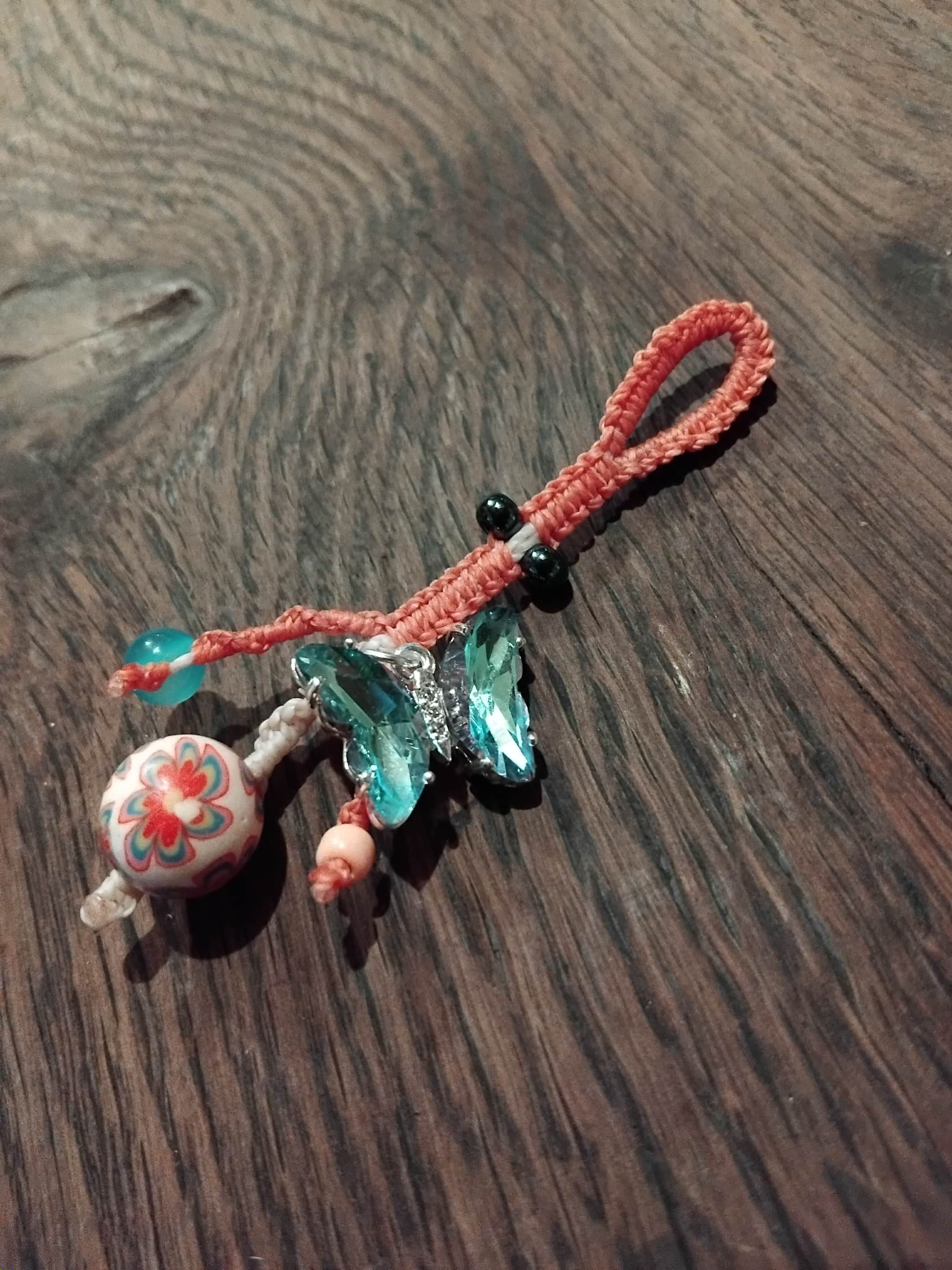 Decorative Macrame Assemblage keychain with colorful beads and pale blue butterfly charm.