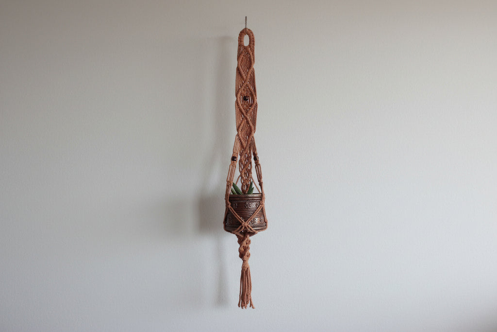 Handcrafted Macrame Planthanger with Woven elements, in warm neutral beige tone.